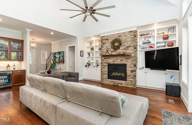 living room with wine cooler, dark hardwood / wood-style flooring, a stone fireplace, a wealth of natural light, and ceiling fan