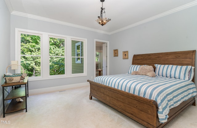 carpeted bedroom with crown molding and ensuite bath