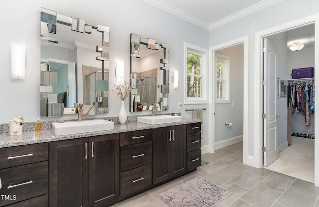 bathroom with double vanity, a sink, a stall shower, and crown molding