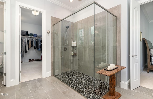 bathroom with a shower stall, crown molding, toilet, and a walk in closet