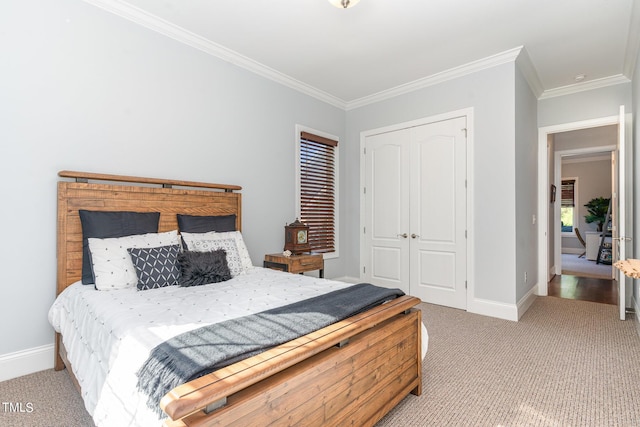 bedroom with baseboards, a closet, ornamental molding, and carpet