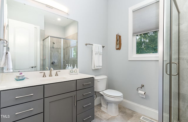 bathroom with tile patterned floors, toilet, a shower with door, and vanity