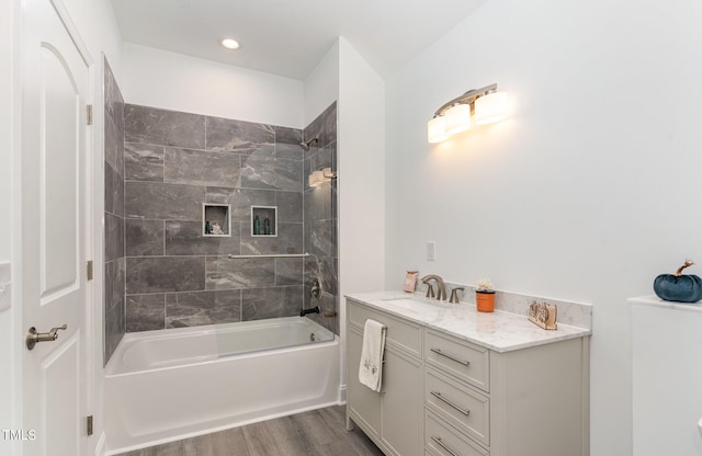 bathroom featuring tiled shower / bath, vanity, and hardwood / wood-style flooring