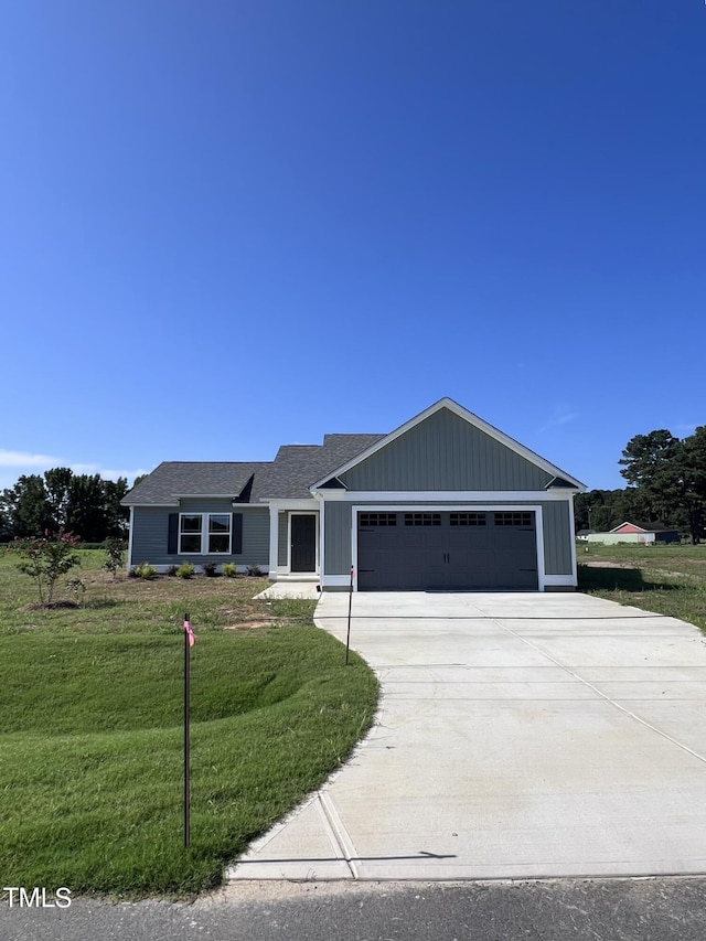 ranch-style house featuring a garage and a front lawn