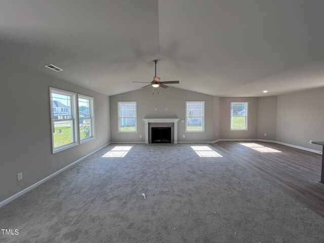 unfurnished living room featuring lofted ceiling, dark carpet, and ceiling fan