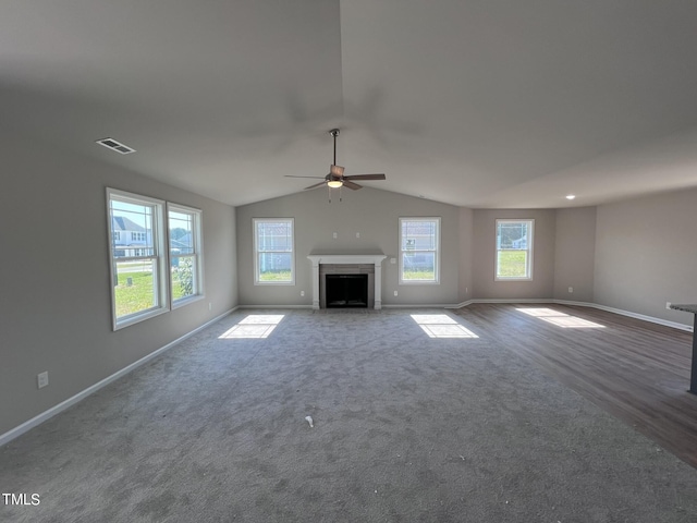 98 Lotus Ave, Smithfield, NC 27577 - unfurnished living room with ceiling fan, visible vents, vaulted ceiling, and a wealth of natural light