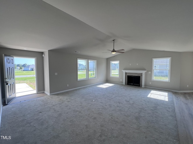 98 Lotus Ave, Smithfield, NC 27577 - unfurnished living room featuring vaulted ceiling, a fireplace with flush hearth, baseboards, carpet floors, and a ceiling fan