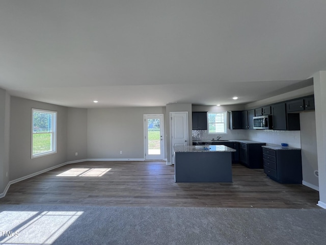 98 Lotus Ave, Smithfield, NC 27577 - kitchen with a kitchen island, baseboards, a sink, and stainless steel microwave