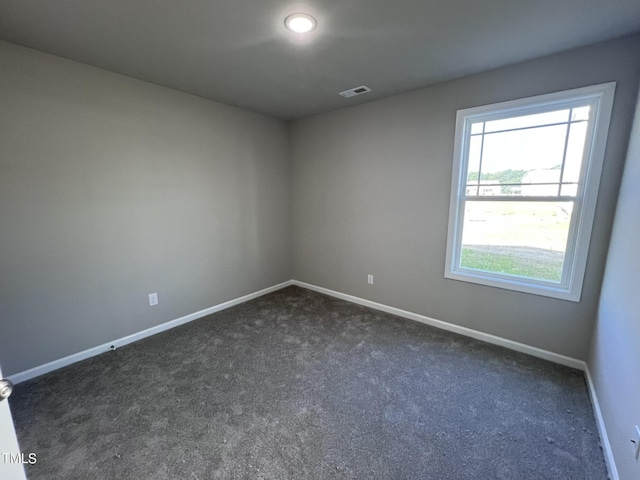 98 Lotus Ave, Smithfield, NC 27577 - spare room featuring dark carpet, baseboards, and visible vents