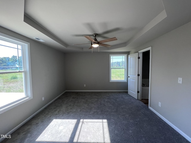 98 Lotus Ave, Smithfield, NC 27577 - unfurnished bedroom featuring visible vents, baseboards, a ceiling fan, dark carpet, and a tray ceiling