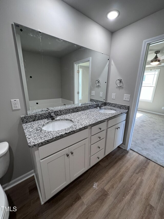 bathroom with ceiling fan, toilet, hardwood / wood-style flooring, and vanity