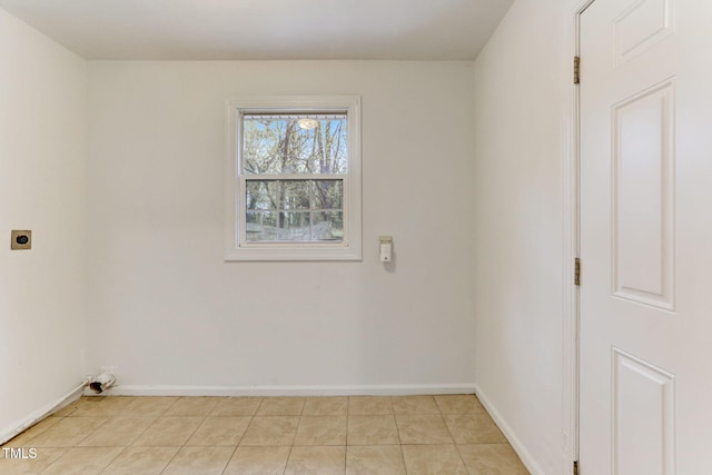 laundry area with electric dryer hookup and light tile patterned flooring