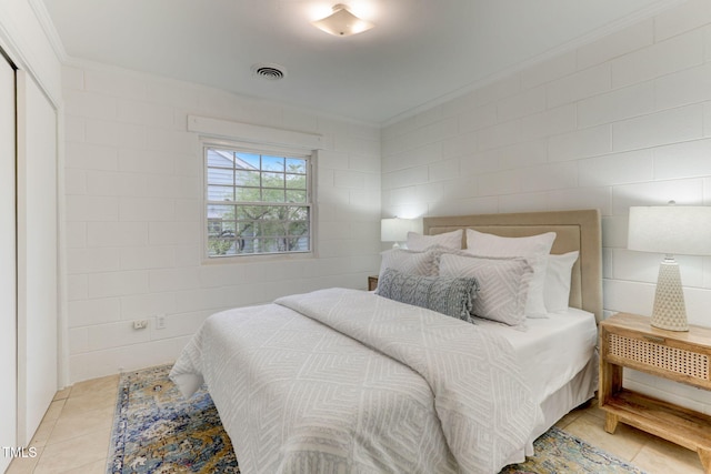 bedroom featuring light tile patterned floors and ornamental molding