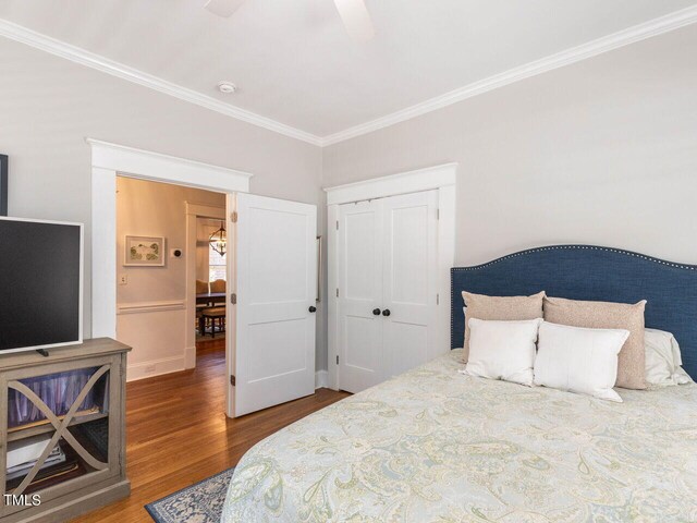 bedroom featuring crown molding, wood-type flooring, ceiling fan, and a closet