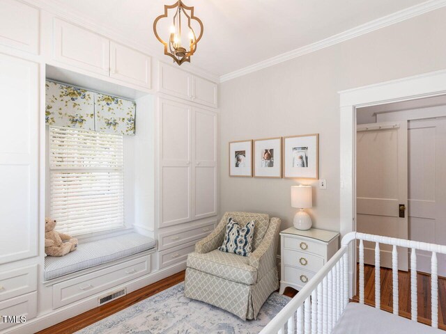 bedroom with ornamental molding, a closet, light wood-type flooring, and a chandelier