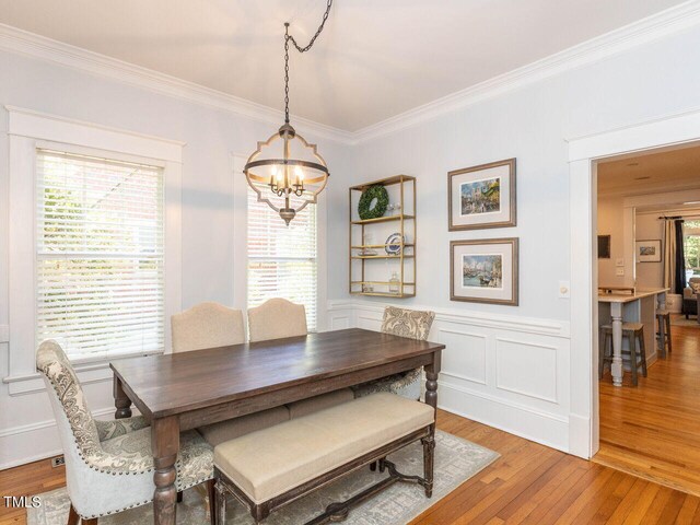 dining space with plenty of natural light, ornamental molding, and light wood-type flooring