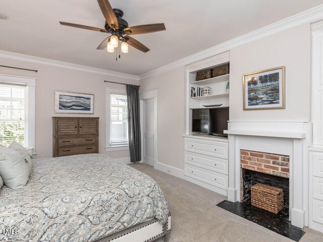 carpeted bedroom featuring ceiling fan, ornamental molding, multiple windows, and a fireplace