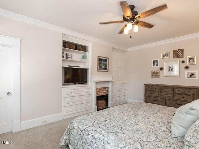 bedroom featuring ceiling fan, ornamental molding, a brick fireplace, and carpet floors