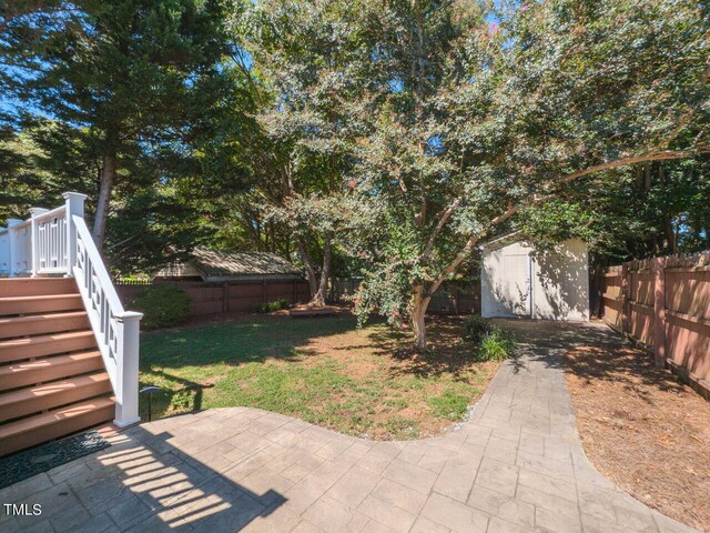 view of yard featuring a shed and a patio area