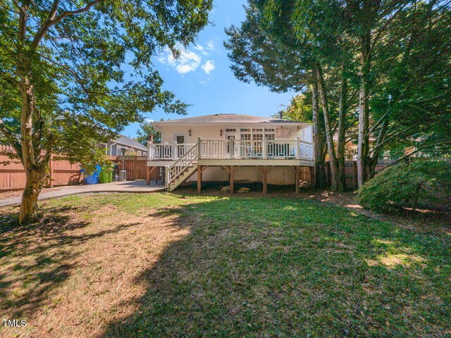 rear view of property featuring a yard and a wooden deck