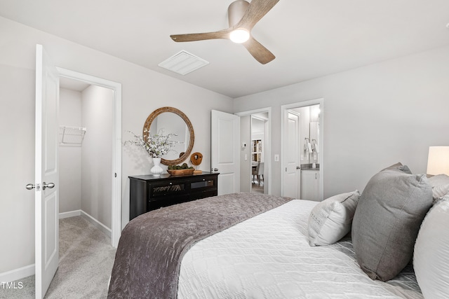 carpeted bedroom featuring connected bathroom, a closet, a spacious closet, and ceiling fan