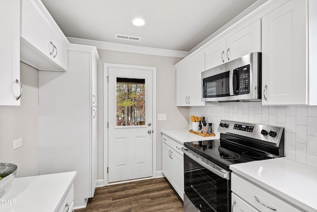 kitchen featuring white cabinets, backsplash, stainless steel appliances, and dark wood-type flooring