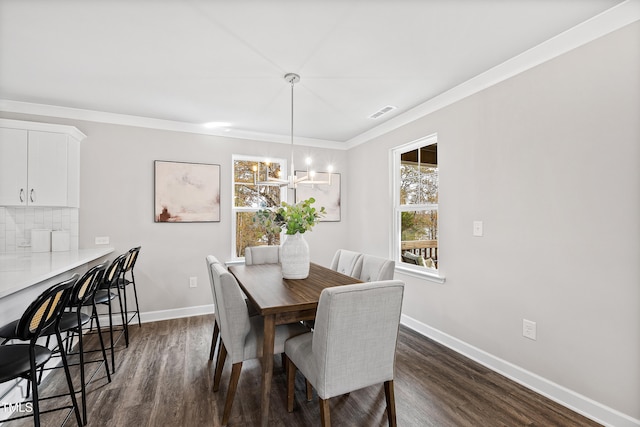 dining room featuring a notable chandelier, dark hardwood / wood-style floors, and ornamental molding