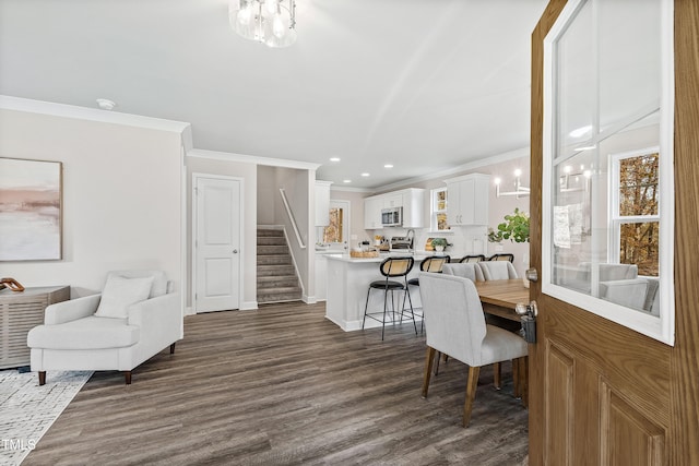 dining area featuring a chandelier, crown molding, and dark wood-type flooring