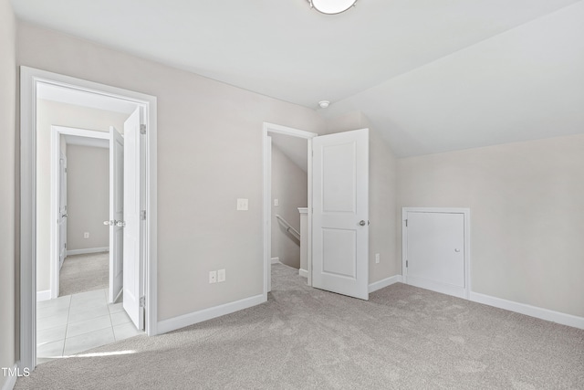 unfurnished bedroom with lofted ceiling and light carpet