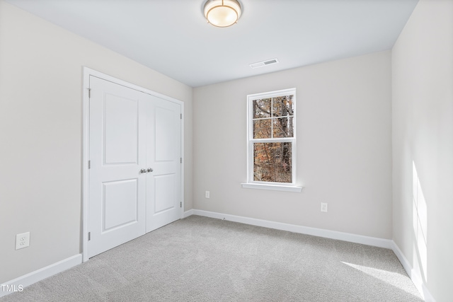 unfurnished bedroom with carpet flooring and a closet