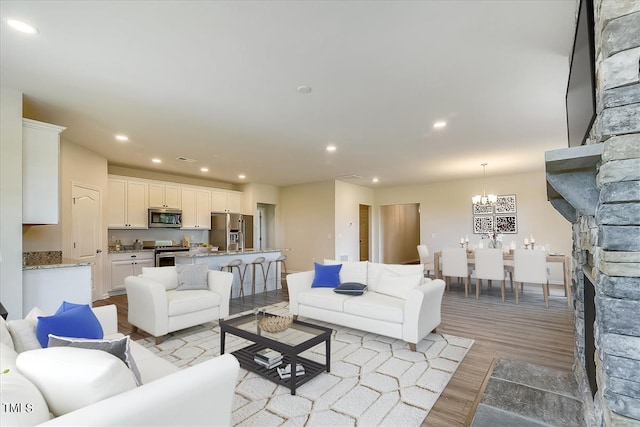 living room with a chandelier and light wood-type flooring