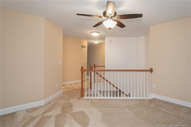 carpeted spare room featuring ceiling fan