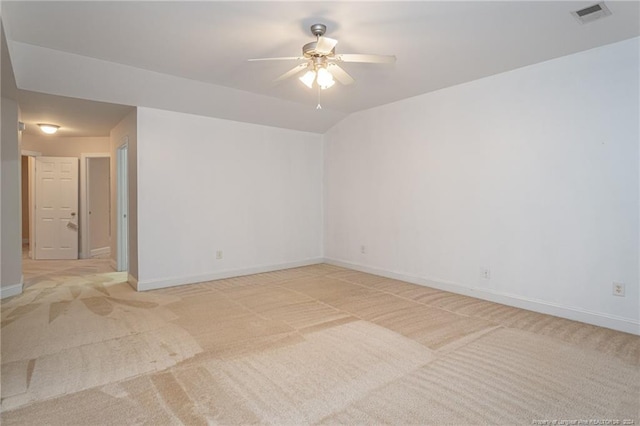 carpeted spare room with ceiling fan and vaulted ceiling