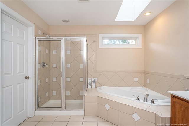 bathroom with vanity, a skylight, independent shower and bath, and tile patterned flooring