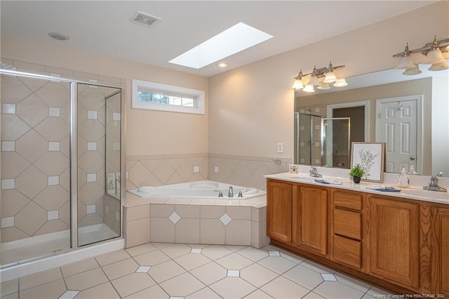 bathroom with vanity, a skylight, independent shower and bath, and tile patterned floors