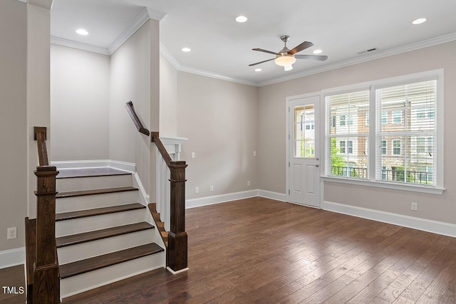 entryway with a ceiling fan, dark wood finished floors, baseboards, visible vents, and ornamental molding