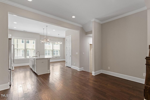 kitchen with an island with sink, a sink, a chandelier, baseboards, and dark wood-type flooring