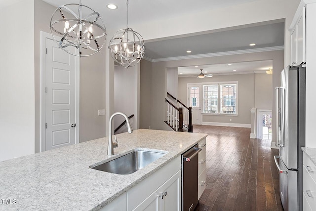 kitchen featuring crown molding, dark wood-type flooring, a sink, white cabinets, and appliances with stainless steel finishes