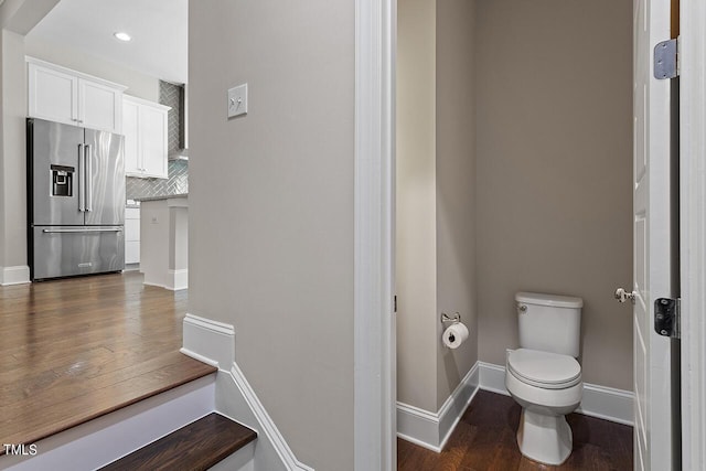 bathroom featuring toilet, tasteful backsplash, wood finished floors, baseboards, and recessed lighting