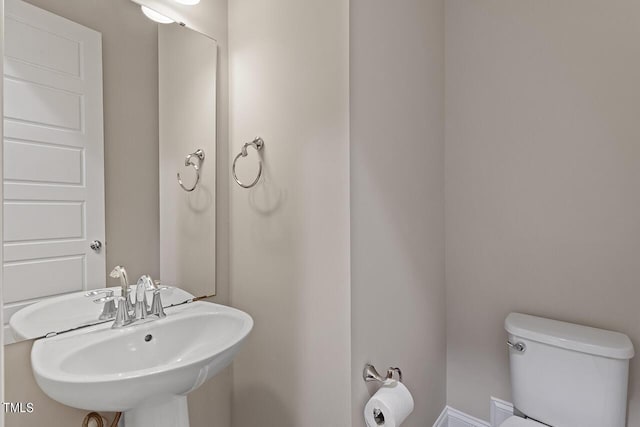 half bathroom featuring a sink and toilet