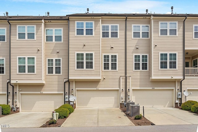 view of front of property featuring central air condition unit, driveway, and a garage