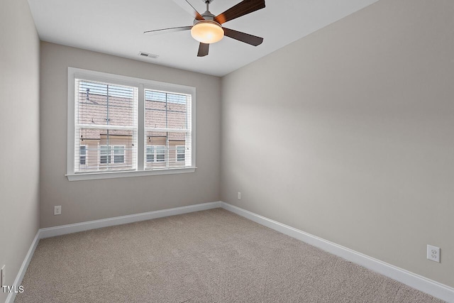 empty room with baseboards, carpet flooring, ceiling fan, and visible vents