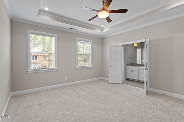 unfurnished bedroom with crown molding, a tray ceiling, ceiling fan, and light colored carpet