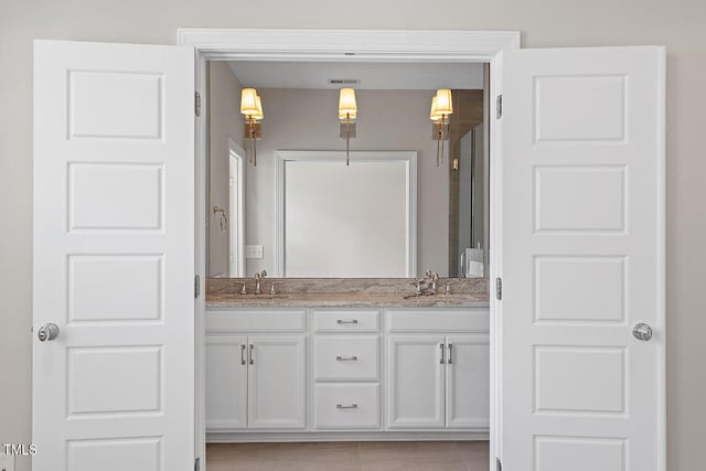 full bathroom with double vanity, a sink, and visible vents