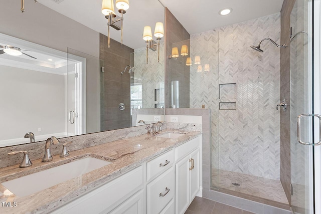 full bathroom featuring double vanity, a sink, tile patterned flooring, and a shower stall