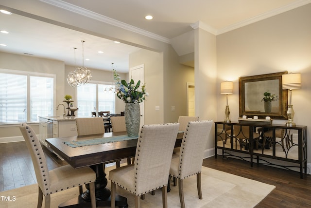 dining area with crown molding, baseboards, a chandelier, and wood finished floors