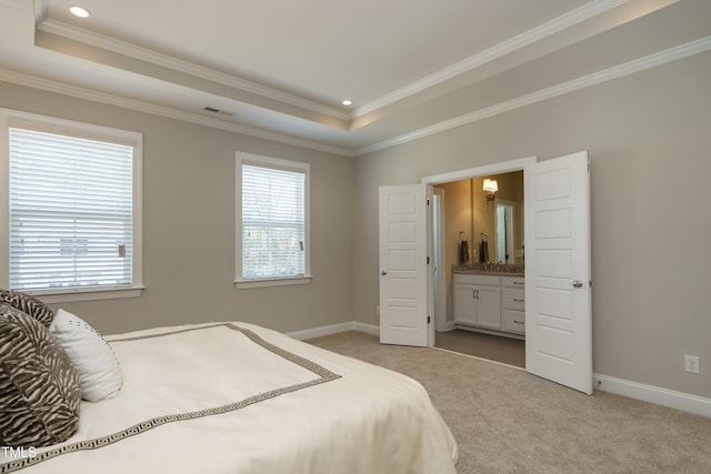 bedroom featuring baseboards, a tray ceiling, multiple windows, and light carpet
