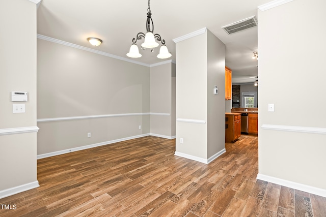 unfurnished dining area featuring ornamental molding, dark hardwood / wood-style floors, and ceiling fan with notable chandelier