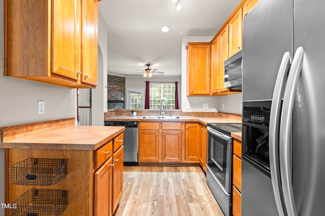 kitchen featuring sink, stainless steel appliances, light wood-type flooring, and ceiling fan