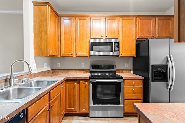 kitchen featuring light hardwood / wood-style floors, ornamental molding, stainless steel appliances, and sink